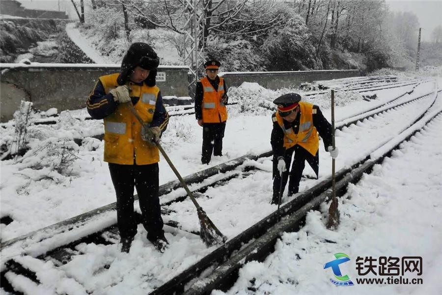 图为：该段普雄车间党总支书记及时组织车站人员对道岔上的积雪进行清扫，确保列车正常运行。.jpg