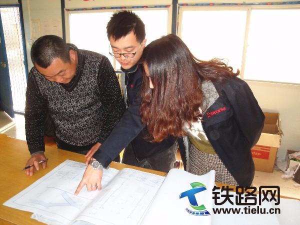 4月7日，该公司新老职工正在一起研究施工图纸.JPG