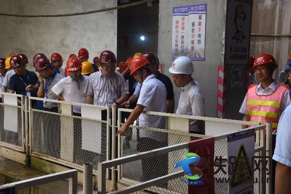 项目负责人向佘才高（左4）报告工程进度.jpg