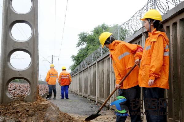 图一为：7月22日，郑州供电段职工雨中巡视接触网供电设备，并对新立供电支柱进行培土加固，确保供电安全稳定。.jpg